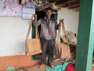Master craftsman displaying handmade leather bags